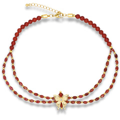 Woman wearing red gemstone necklace with butterfly pendant
