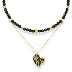 Women's onyx and black tourmaline choker with gold heart pendant on white background