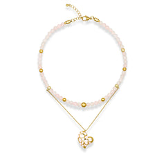 Women's rose quartz choker necklace with gold heart pendant on white background