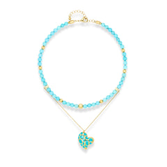 Women's turquoise choker necklace with gold heart pendant on white background