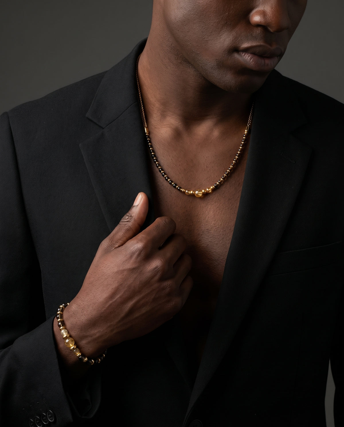 Model wearing an Alfabeads Citrine and Smoky Quartz necklace and matching bracelet with a black blazer